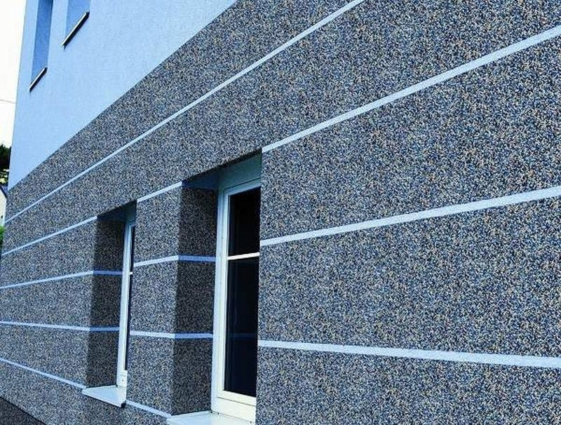 A Retrofit Coordinator inspecting an external wall insulation project on a UK residential property to ensure PAS 2035 compliance.